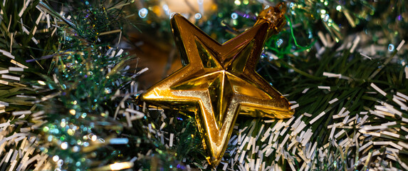 A Christmas star between Christmas balls and garland, Christmas decoration with a star in the foreground. Christmas decoration concept with star