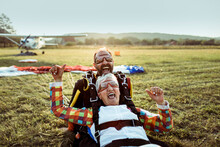 Senior female skydiver and her skydiving instructor landing after skydiving from a plane