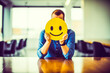 Homme dans son bureau plaçant un énorme émoticône souriant jaune devant son visage