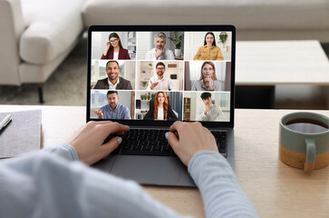 Wall Mural - Woman participating in webinar via laptop at table, closeup