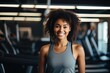 © NikoG - Smiling portrait of a happy young female african american fitness instructor working in an indoor gym