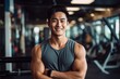 Leinwanddruck Bild - Smiling portrait of a happy young male asian american fitness instructor in an indoor gym
