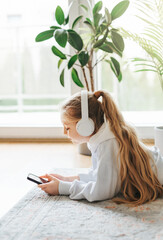 Wall Mural - Little girl listening music lying on the floor