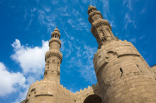 Bab Zuweila Minaret Twin Towers Against A Blue Sky With White Cirrus Clouds, One Of Three Remaining Gates In City Wall Of The Old City Of Cairo, Capital Of Egypt, One Of The Major Landmarks Of City