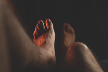 Male Feet In The Dark. Close-up Of Man's Bare Feet