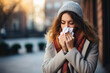 Cold and flu season: unhealthy woman outdoors in autumn with a handkerchief