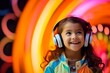 Portrait of a cute little girl listening to music with headphones on a colorful background