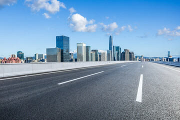 Asphalt highway road and city skyline with modern buildings