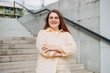 © mdyn - Head shot portrait smart confident smiling millennial woman standing with folded arms on urban background. Attractive young student girl freelancer looking at camera. Urban lifestyle concept.