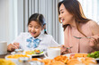 © sorapop - Asian family breakfast. smiling mother and child daughter having breakfast on food table, Healthy food at home before go to school, Mom and little preschooler have fun eating meal together