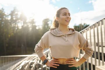 Fitness woman doing sports outdoors in an urban environment. A sports woman in special clothes does exercises. Active lifestyle, training. Lifestyle.