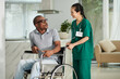 © DragonImages - Man with disability asking social worker to help him with wheelchair