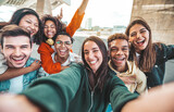 Fototapeta Londyn - Multiracial young people laughing together at camera - Happy group of friends having fun taking selfie pic with smart mobile phone - Youth community concept with guys and girls hugging outdoors