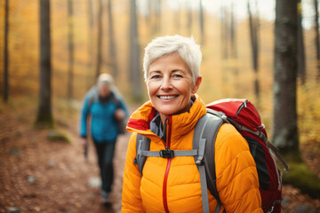 Portrait of mature senior woman hiking in autumn forest. Concept of travel lifestyle adventure active vacations outdoor and healthy.