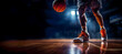 Closeup of legs of a professional basketball player in a sport hall with dramatic light. Copy space