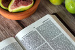 © Marinela - Fresh figs and open holy bible book on wooden table. Jeremiah 24 prophecy verses, Old Testament Scripture.
