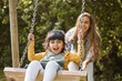 © Wesley/peopleimages.com - Happy, swing and mother and child in park for playing, bonding and having fun together outdoors. Nature, weekend and mom push little girl in playground for relaxing, childhood and happiness in summer
