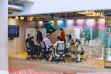 Wall Mural - In the vibrant ambiance of a modern startup office, a diverse group of businesspeople gathers around a meeting table, exemplifying teamwork, collaboration, and the dynamic spirit of contemporary