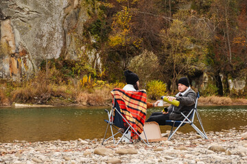 Wall Mural - happy couple having picnic at river beach