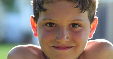 Wall Mural - Boy child smiling to camera portrait face outdoors at park