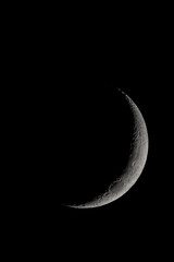 Wall Mural - crescent moon photographed with a telescope, where you can see the craters and the lunar surface, it