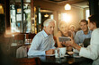© Marko Geber - Diverse group of business coworkers using a smartphone while having a meeting in a cafe or bar