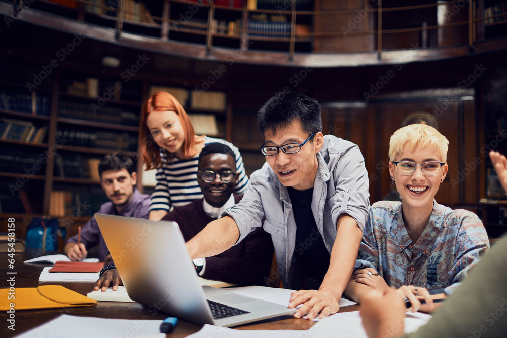 Young and diverse group of students using the laptop and studying in an ...