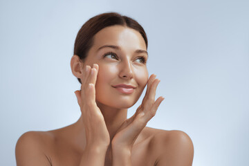 skincare. woman with beautiful face touching healthy facial skin. beautiful portrait of smiling asia