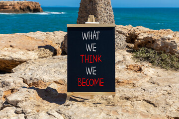 We become or think symbol. Concept word What we think We become on beautiful black chalkboard. Beautiful stone sea background. Business we become or think concept. Copy space.