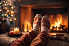 Feet In Woollen Socks By The Christmas Fireplace. Close Up On Feet. Winter And Christmas Holidays Concept.