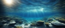 Deep Blue Ocean With Sunlight Streaming Through The Water And A Rocky Empty Bottom