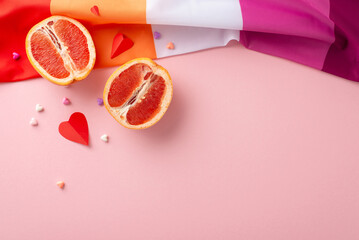 Wall Mural - Bird's-eye perspective of Lesbian Pride elements: a fluid flag, small hearts, and grapefruits as a symbol of femininity, positioned on a soft pink backdrop, offering room for text or advertisements