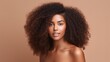 Lovely ebony woman. On a beige background, a beauty portrait of an African American woman with clean, healthy skin. Beautiful afro girl with a smile. 