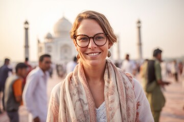 Wall Mural - Group portrait photography of a satisfied woman in her 30s that is wearing a chic cardigan in front of the Taj Mahal in Agra India