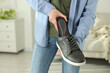 © New Africa - Man putting orthopedic insole into shoe indoors, closeup. Space for text