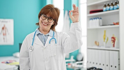 Wall Mural - Middle age woman doctor doing ok gestur at clinic