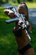 © Михаил Решетников - Caucasian woman in bikini with machine gun outdoors.