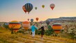 © Fokke Baarssen - Kapadokya Cappadocia Turkey, a happy young couple during sunrise watching the hot air balloons of Kapadokya Cappadocia Turkey during vacation