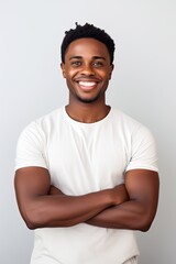 Wall Mural - Young smiling African American man with arms crossed.