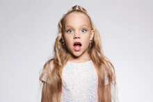 Little Girl In Beautiful Dress And Make-up. Portrait Of Funny Child. Blonde