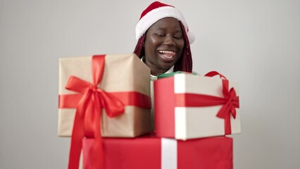 Sticker - African woman with braided hair wearing christmas hat holding gifts over white background