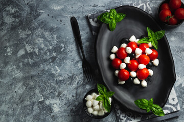 Wall Mural - Caprese with cherry tomatoes, mini mozzarella, fresh basil leaves, Traditional italian food, antipasto. banner, menu, recipe place for text, top view