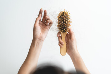 Close-up young woman brushing her hair and have many hair loss on the comb