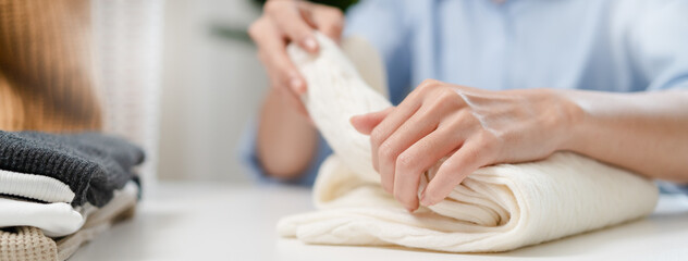 Close up hands people organizing clean clothes after laundry