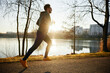 © baranq - Male runner in park during autumn or winter sunset