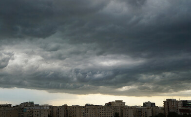 Dramatic storm cloudy sky over Bucharest city. Storm dark grey clouds over Bucharest city apartment blocks landscape. Bucharest, Romania cityscape