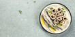 plate of canned anchovy fillets on a light background, Long banner format. top view