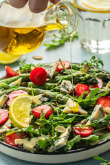 Wall Mural - diet summer salad with strawberries, asparagus, arugula, blue cheese and seeds. Food recipe background. Close up