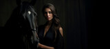 Fototapeta  - Elegance and Power: A Woman's Connection with Her Majestic Black Horse in Dark Tones. In the Shadows of Elegance