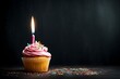 Happy Birthday cupcake with candle on side of blackboard empty